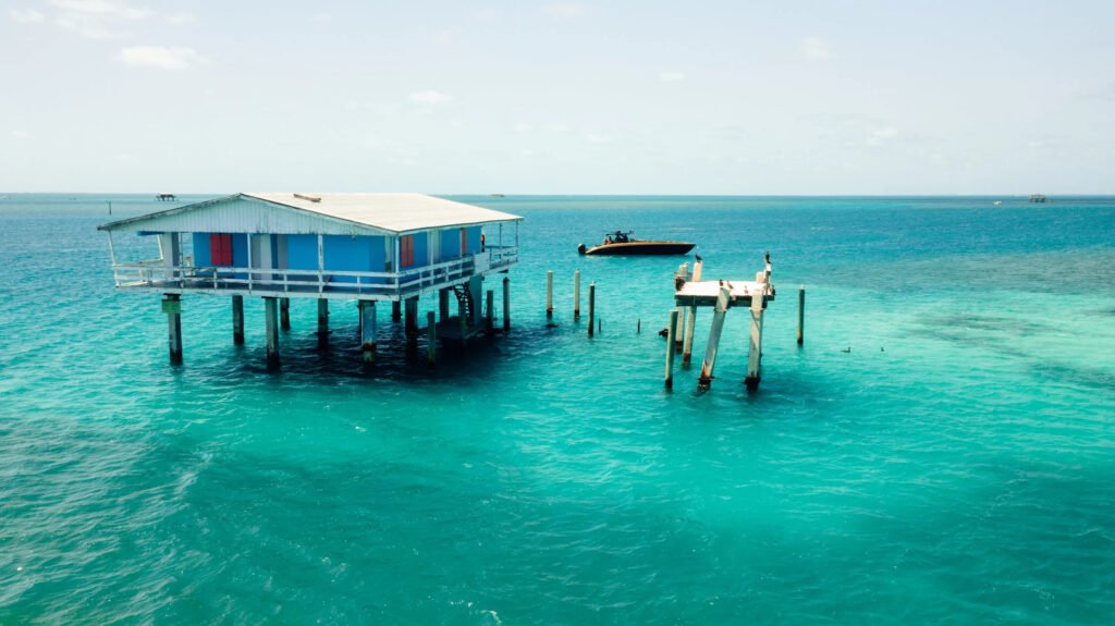 Blue Stiltsville house on Biscayne Bay in Key Biscayne, Florida with a boat anchored nearby.