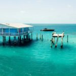 Blue Stiltsville house on Biscayne Bay in Key Biscayne, Florida with a boat anchored nearby.
