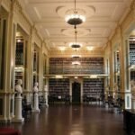 Boston Athenaeum reading room with tall bookshelves, statues, and chandeliers in Boston, Massachusetts.