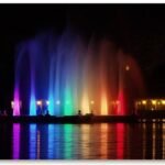 Vibrant rainbow lights reflecting on the water at the Prismatic Electric Fountain in Denver