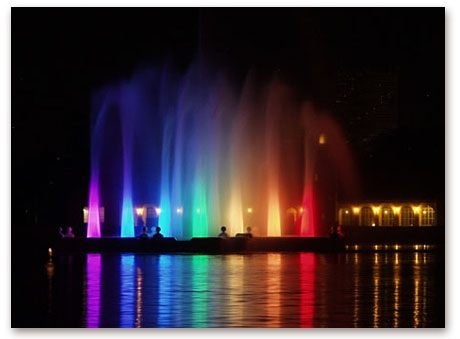 Vibrant rainbow lights reflecting on the water at the Prismatic Electric Fountain in Denver