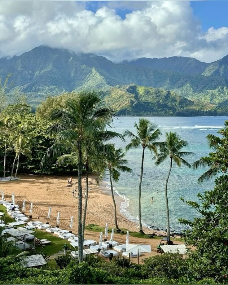 View of 1 Hotel Hanalei Bay in Kauai, one of the top eco-friendly hotels in Hawaii, overlooking the ocean and lush green mountains.