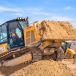 Visitor driving a bulldozer and moving dirt at Dig This Las Vegas experience.
