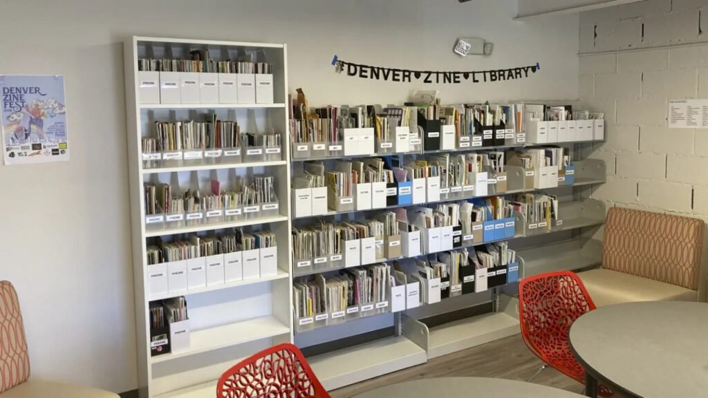 Modern shelves at the Denver Zine Library displaying categorized zines in the Bob Ragland Branch.