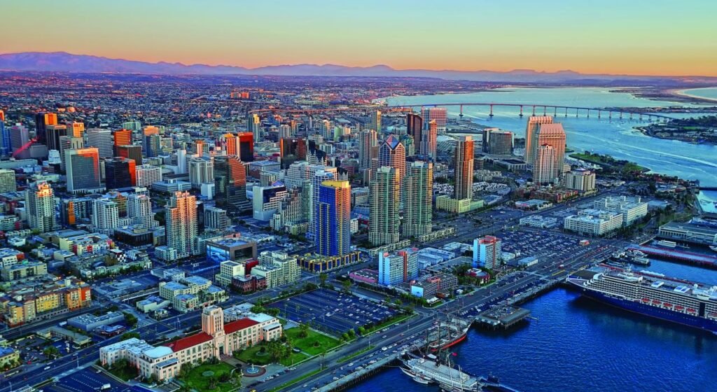 Aerial view of downtown San Diego with the bay and Coronado Bridge at sunset.