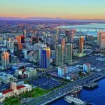 Aerial view of downtown San Diego with the bay and Coronado Bridge at sunset.