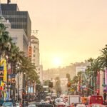 Sunset view of Hollywood Boulevard in Los Angeles with palm trees and traffic — one of the top LA film locations you can visit.