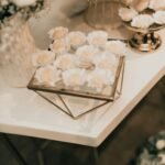 Dessert table setup for wedding planning in Hawaii featuring floral-themed sweets and elegant gold décor.