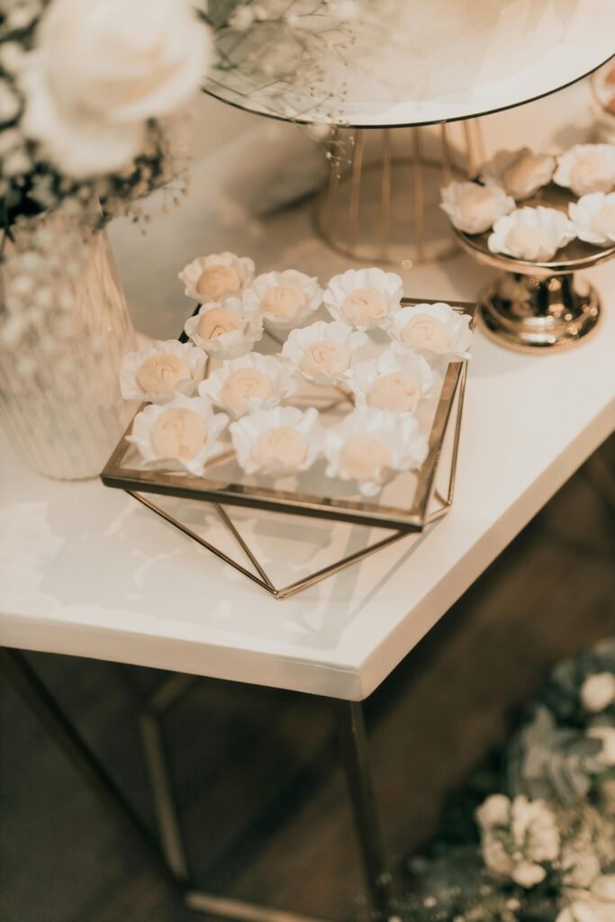 Dessert table setup for wedding planning in Hawaii featuring floral-themed sweets and elegant gold décor.
