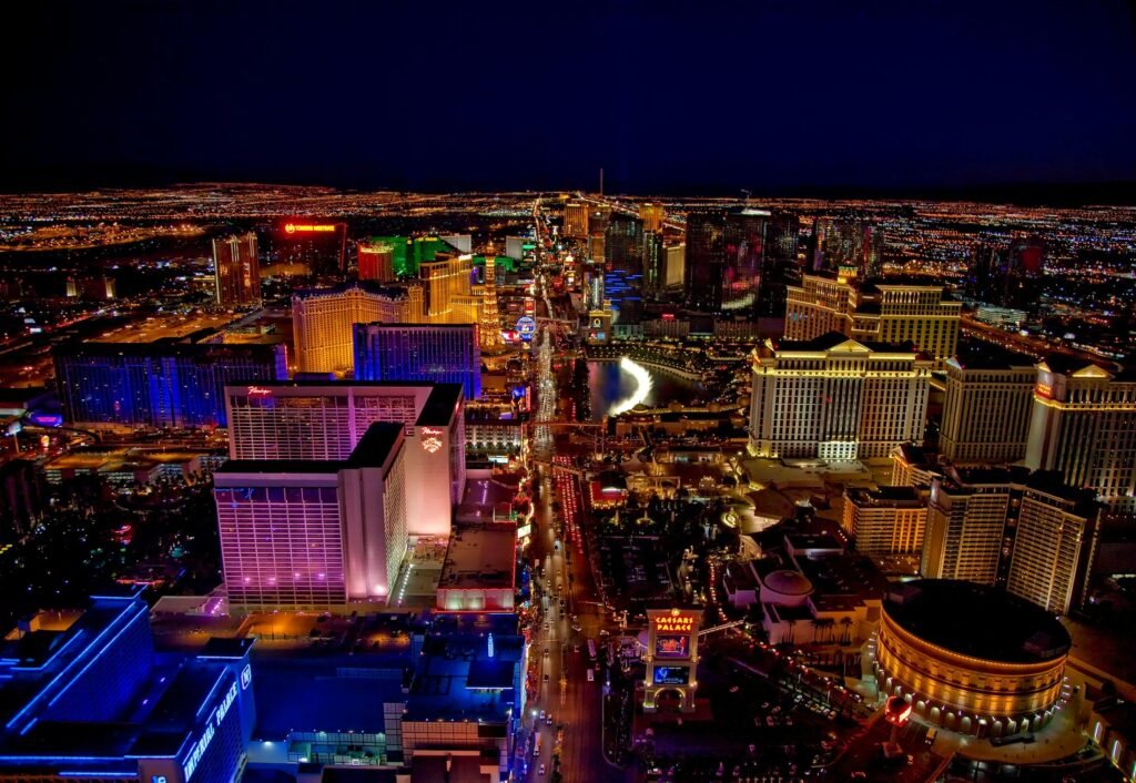 Aerial view of the Las Vegas Strip at night with colorful lights and famous hotels.