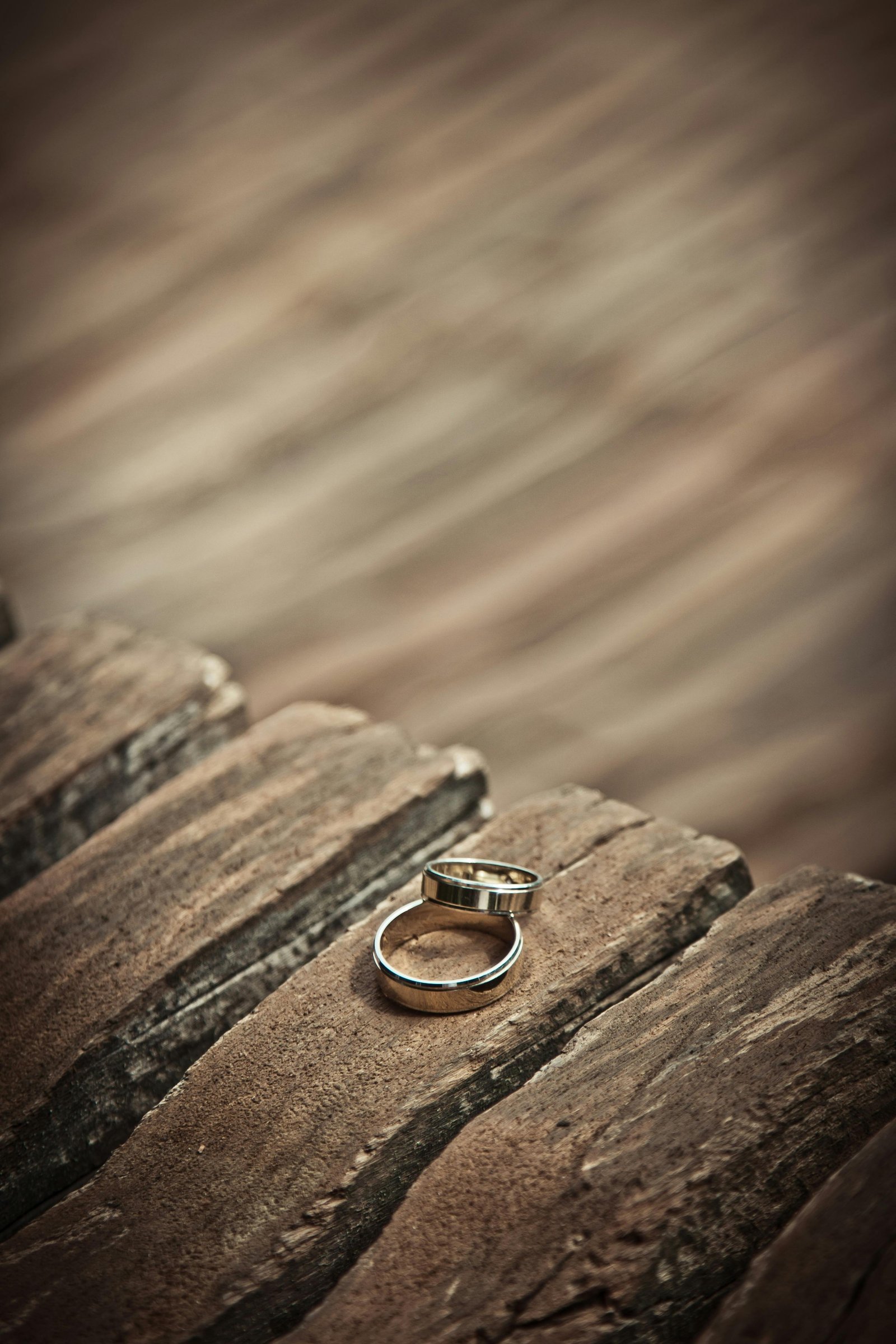 Gold wedding rings on wood representing elegant desert elopement wedding ideas and rustic themes.