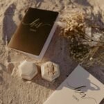 Wedding vow books and gold rings on sandy beach for a destination wedding in Florida on a budget