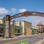 Historic Temecula arch sign at the entrance of Old Town Temecula with colorful buildings and clear blue sky.